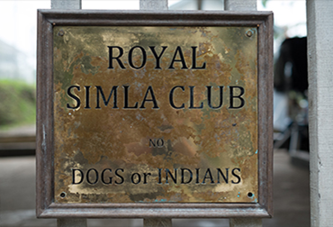Entrada al Royal Simla Club con el cartel que prohíbe la entrada a “perros o indios” manifestando el profundo racismo de la época.
